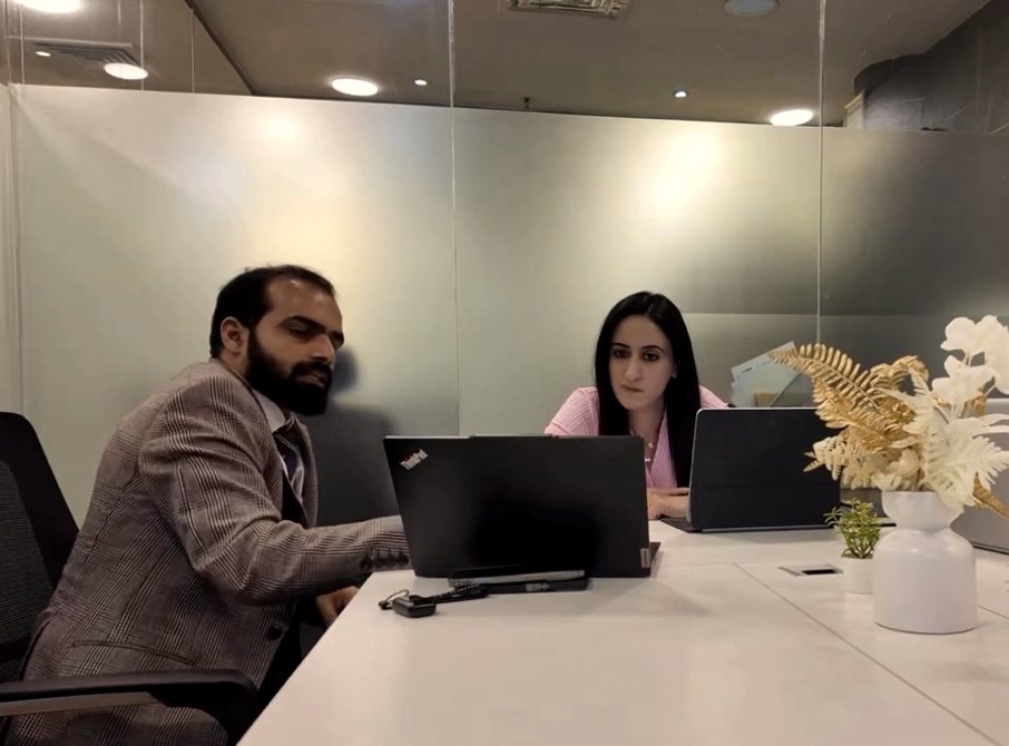 Mehak Butt and a colleague reviewing a company setup plan on laptops